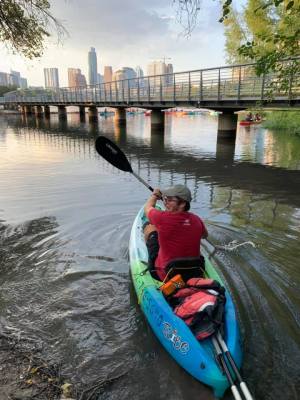 a man sitting on the side of a bridge over a body of water