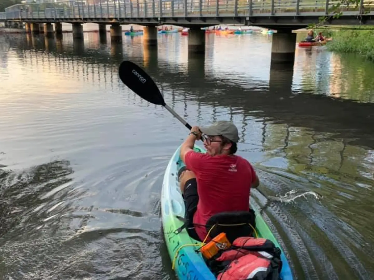 a man sitting on the side of a bridge over a body of water